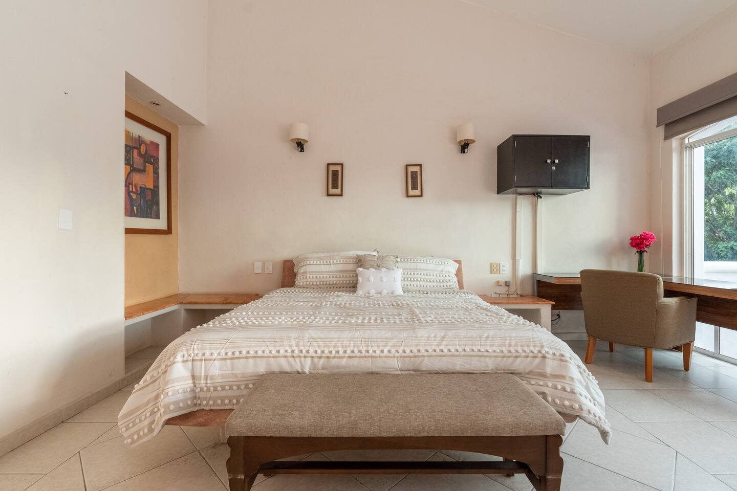 Home Bedroom with a bench at the foot of the bed and a desk with an armchair