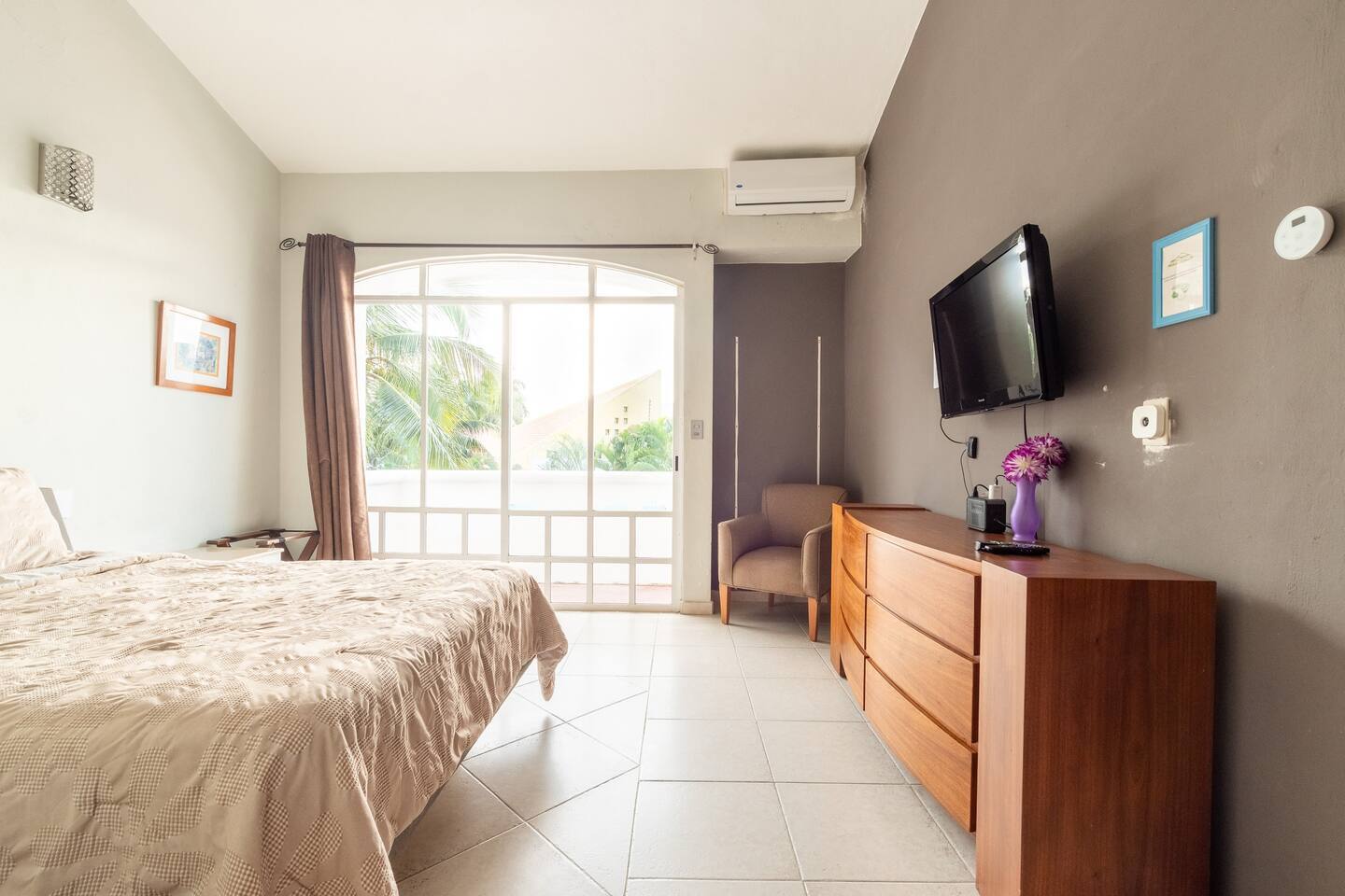 Home Bedroom with a dresser, a wall TV and a tall window opening onto the terrace